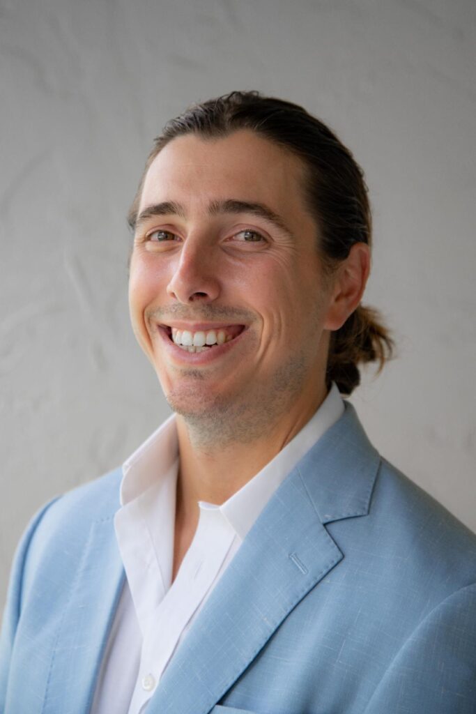 A man in a blue suit smiling for the camera.