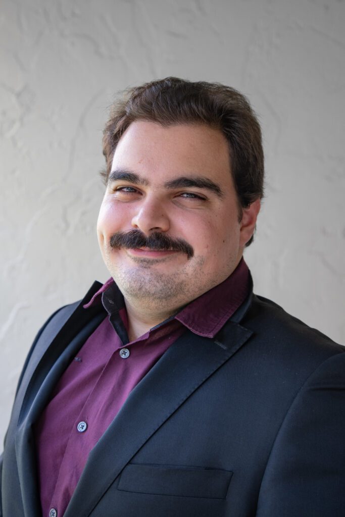 A man with a mustache wearing a suit and tie