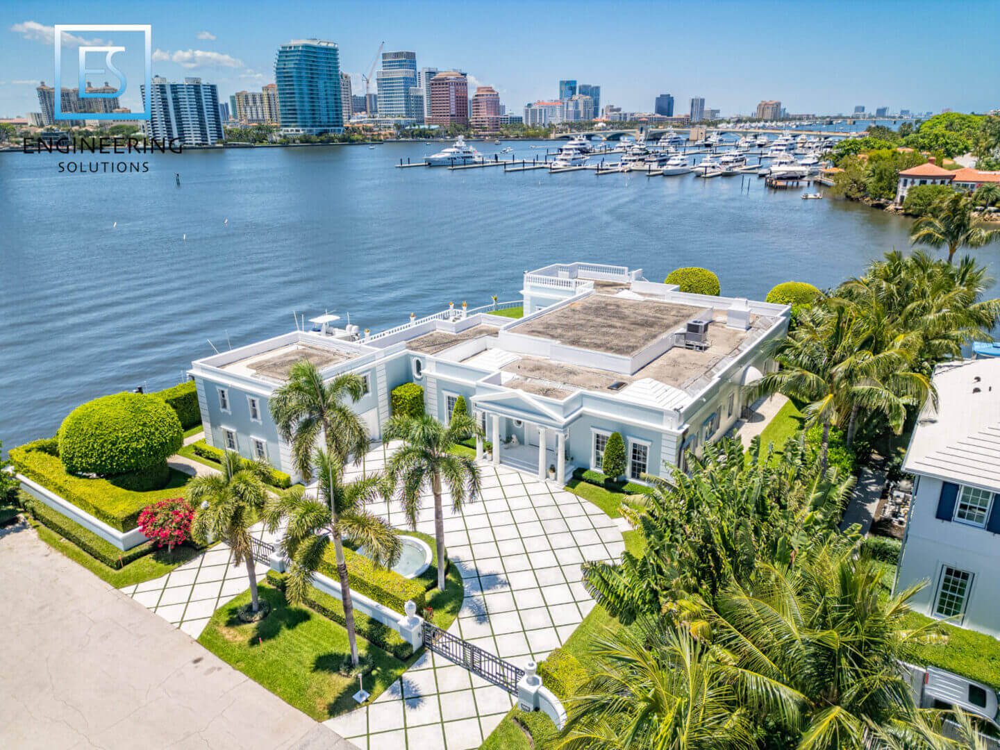 Waterfront mansion with city skyline view.