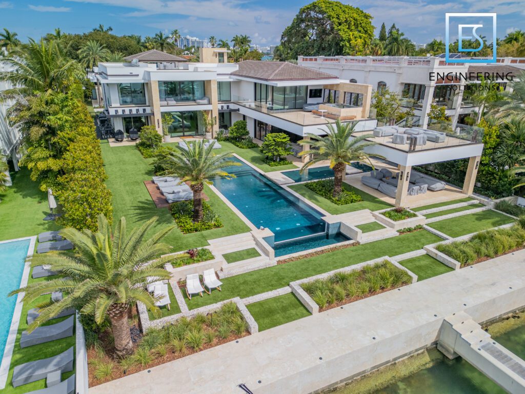 A large pool surrounded by grass and palm trees.