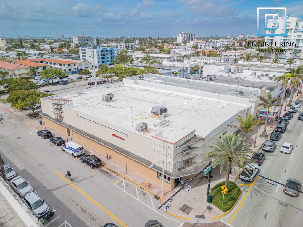 A large building with many cars parked on the side of it.