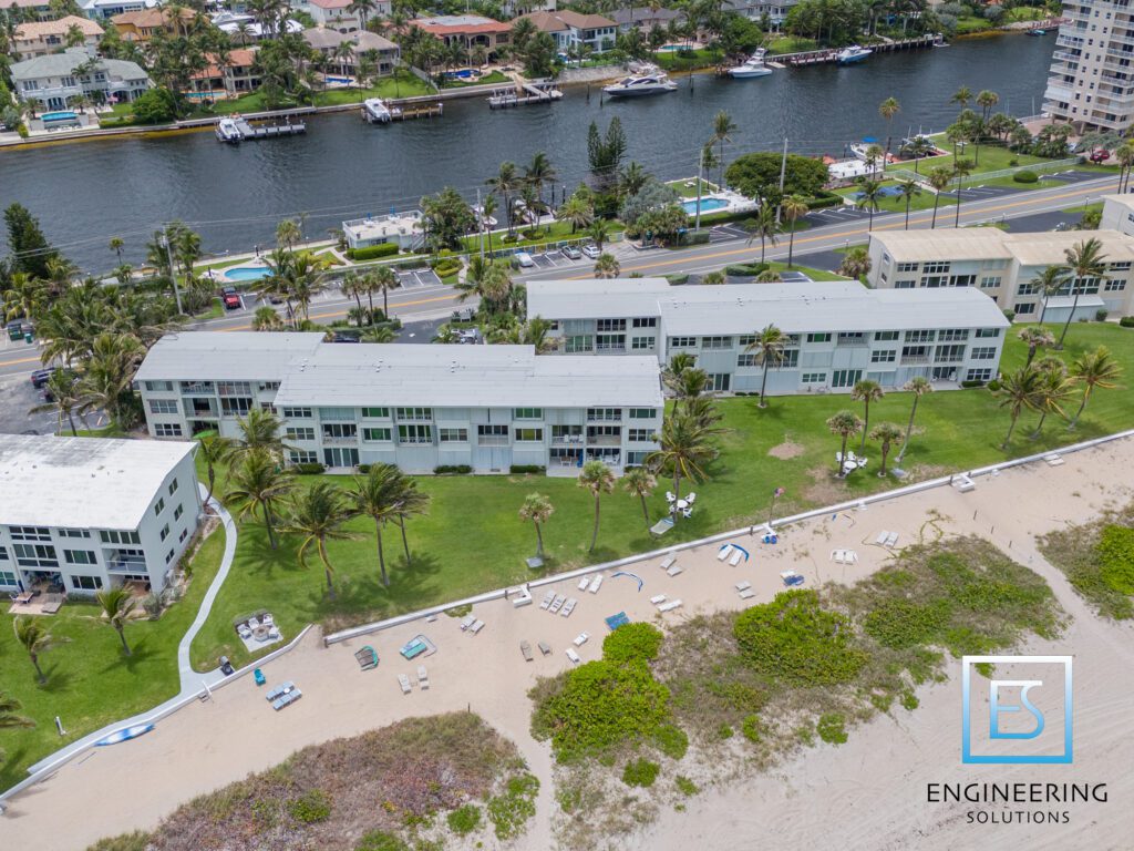 A view of the beach from above shows some buildings and water.