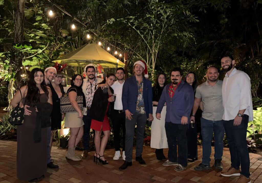 Group celebrating outdoors under string lights.
